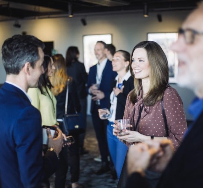 Leende Kvinna Och Man StÂende PÂ Mingel PÂ Kontor